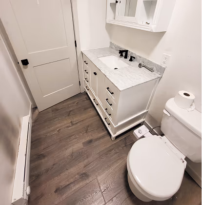 a remodeled bathroom with new floors and fixtures